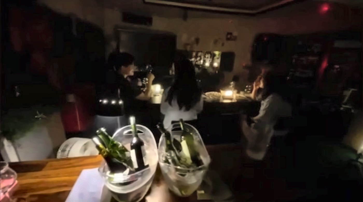 촛불 아래 와인을 마시며 이야기하는 참가자들